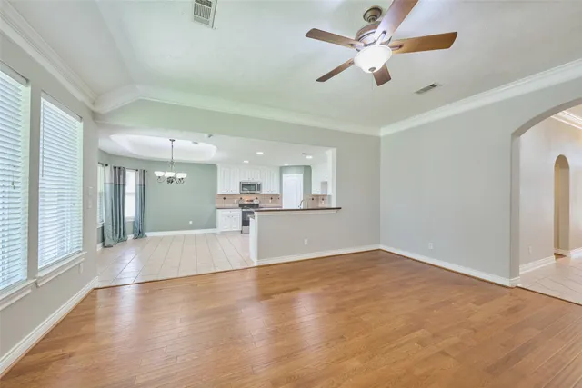 a view of an empty room with a fireplace and a fan