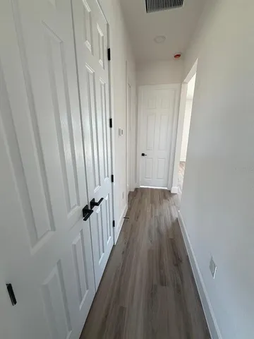 a view of a hallway with wooden floor