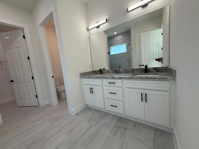 a bathroom with a granite countertop sink double and mirror