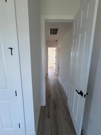 a view of a hallway with wooden floor