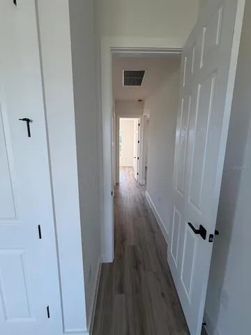 a view of a hallway with wooden floor