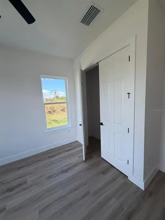 an empty room with wooden floor and window