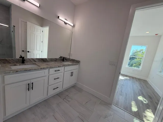 a bathroom with a granite countertop sink and a vanity