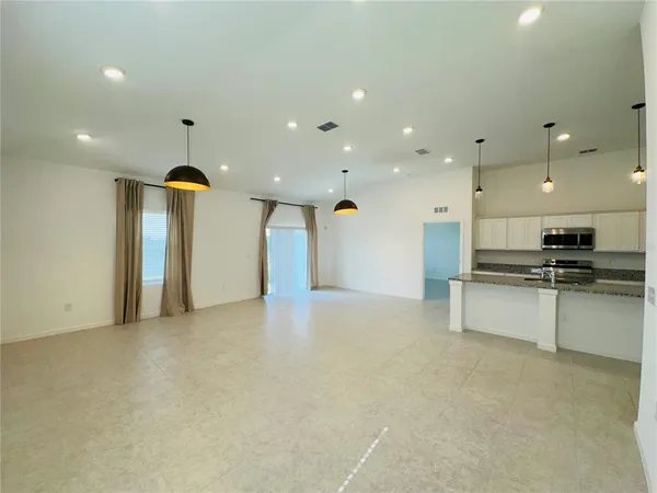 a view of an empty room with a kitchen