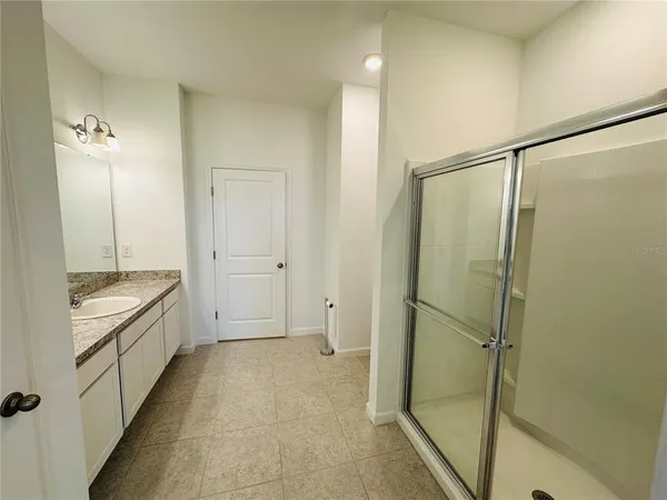 a bathroom with a granite countertop bathtub shower sink and mirror