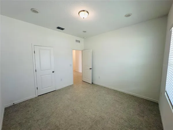 an empty room with closet and windows