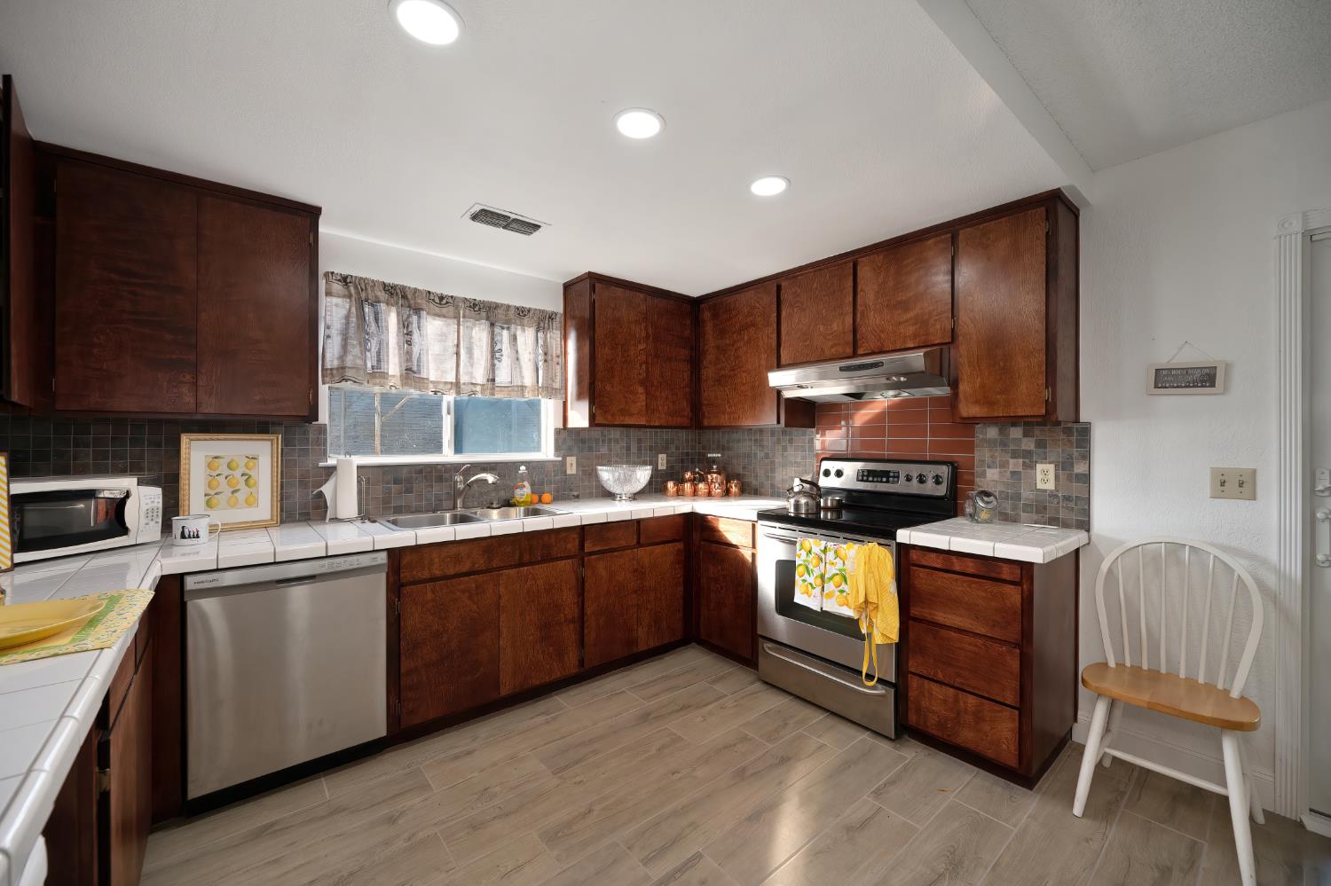 4271 Soledad Avenue Sacramento, CA 95820 - Photo 17 of 36 a kitchen with stainless steel appliances granite countertop wooden cabinets a stove top oven a sink and dishwasher