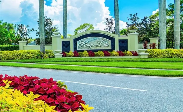 a front view of a house with a garden and trees