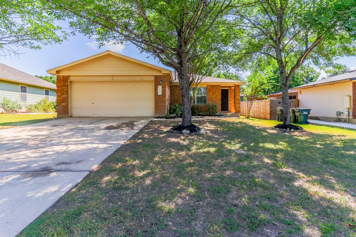 a view of a house with a yard and large tree