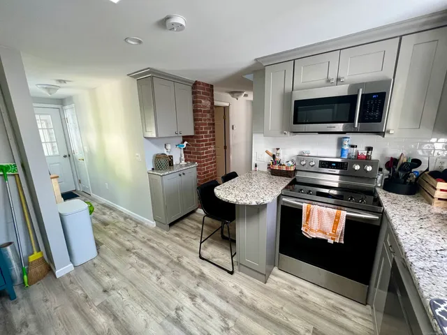 a kitchen with stainless steel appliances a stove a sink and a microwave