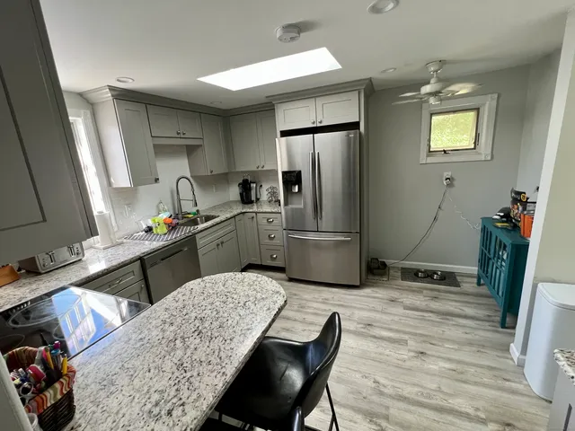 a kitchen with refrigerator and chairs