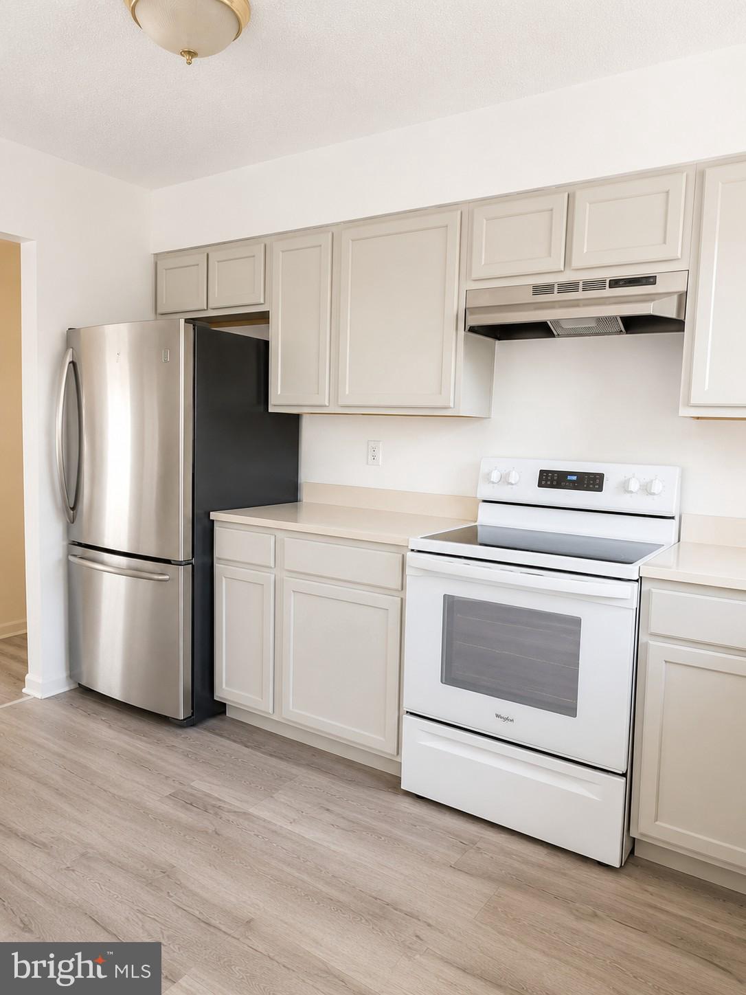 6204 Cipriano Road Lanham, MD 20706 - Photo 6 of 19 a kitchen with stainless steel appliances white cabinets and a refrigerator