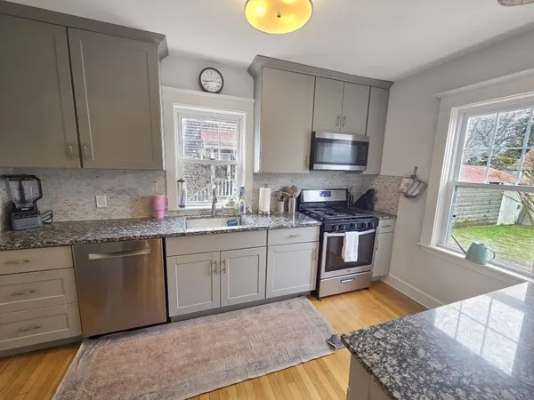 a kitchen with stainless steel appliances granite countertop a sink stove and cabinets