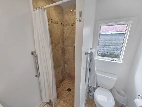 a bathroom with a toilet and a shower