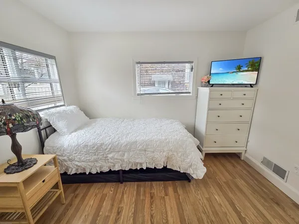 a bedroom with a bed and wooden floor
