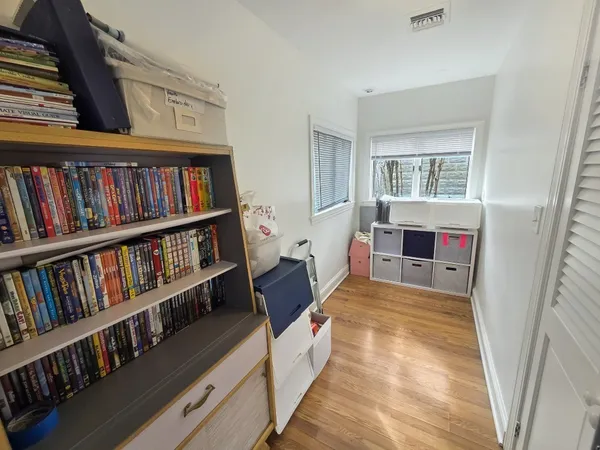 a bedroom with furniture book shelf and a window