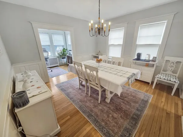 a view of a dining room with furniture a rug and wooden floor
