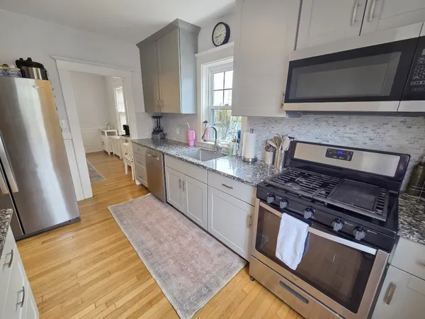a kitchen with stainless steel appliances granite countertop a stove a sink and a microwave
