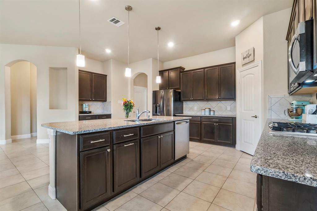 3610 Bastrop Street Melissa, TX 75454 - Photo 5 of 23 a large kitchen with granite countertop a large counter top stainless steel appliances and cabinets