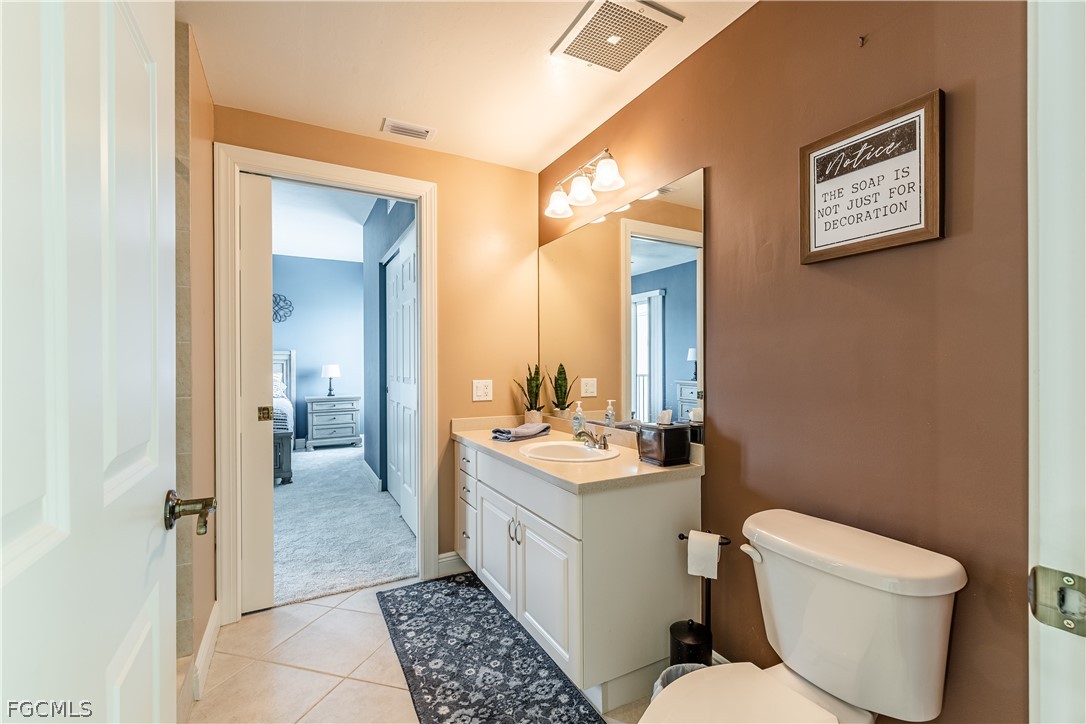 2743 First Street, Unit 2206 Fort Myers, FL 33916 - Photo 29 of 38 a bathroom with a toilet sink and mirror