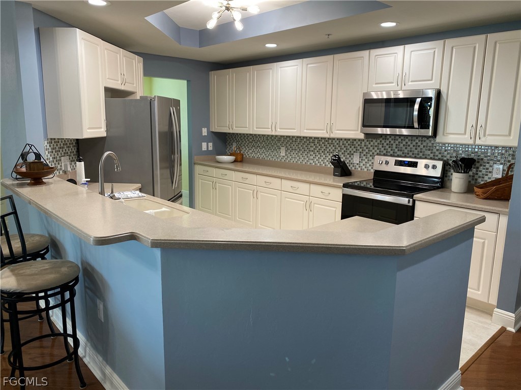 2743 First Street, Unit 2206 Fort Myers, FL 33916 - Photo 6 of 38 a kitchen with kitchen island granite countertop a sink stove and refrigerator
