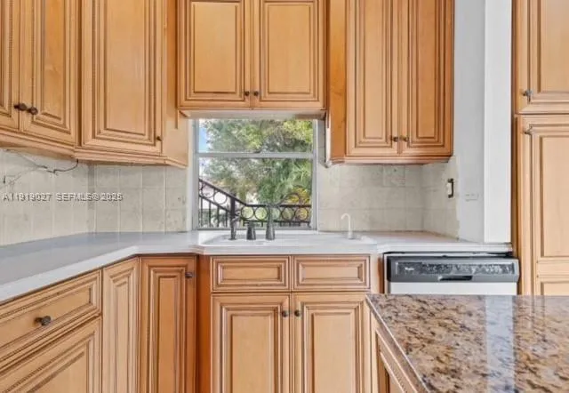 a kitchen with granite countertop white cabinets and stainless steel appliances