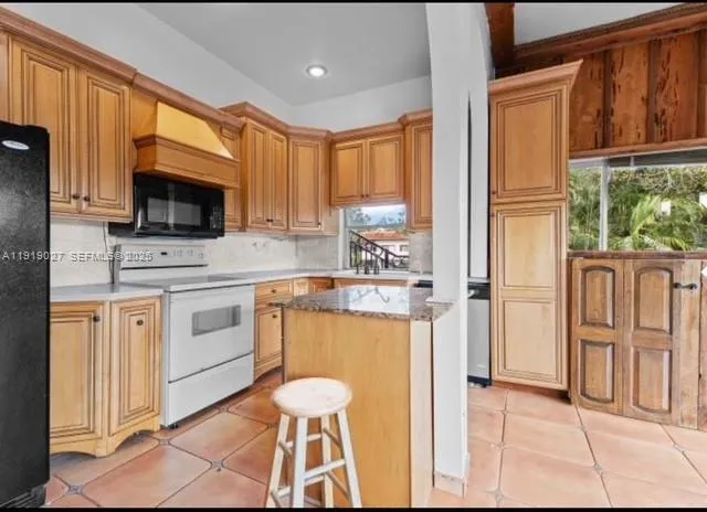 a kitchen with stainless steel appliances a stove top oven cabinets a refrigerator and a sink