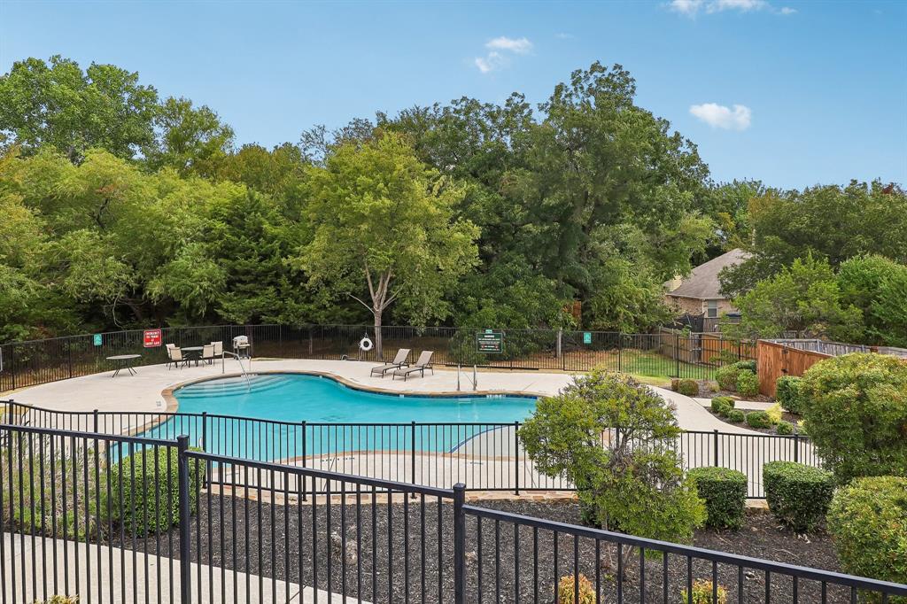 101 Ravinia Court Oak Point, TX 75068 - Photo 22 of 23 Fenced swimming pool with integrated steps, surrounded by a concrete deck and mature landscaping