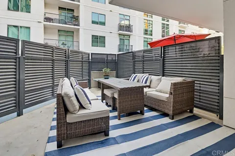 a view of a patio with couches table and chairs and wooden floor