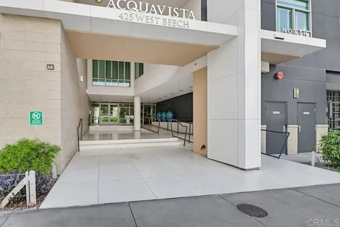 a view of a building with a potted plant and floor to ceiling window