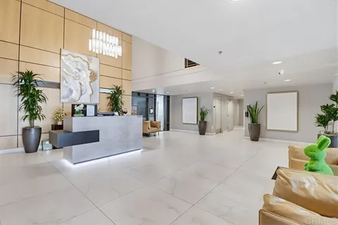 a lobby with furniture and potted plants