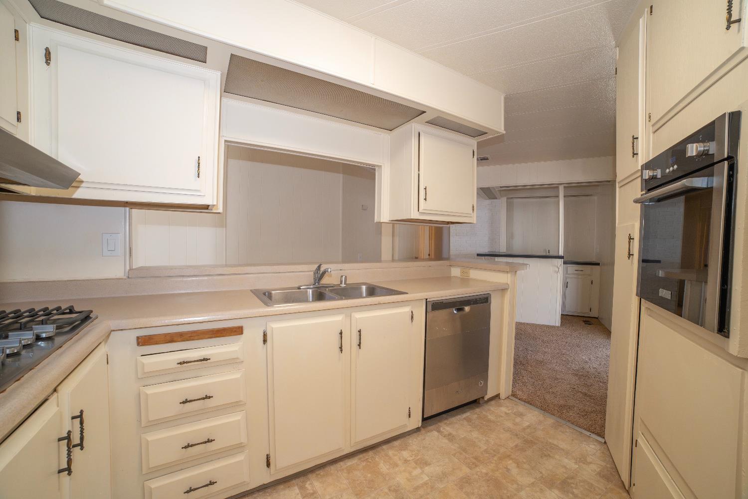 1200 South Carpenter Road, Unit 71 Modesto, CA 95351 - Photo 16 of 27 a kitchen with a sink stove and cabinets