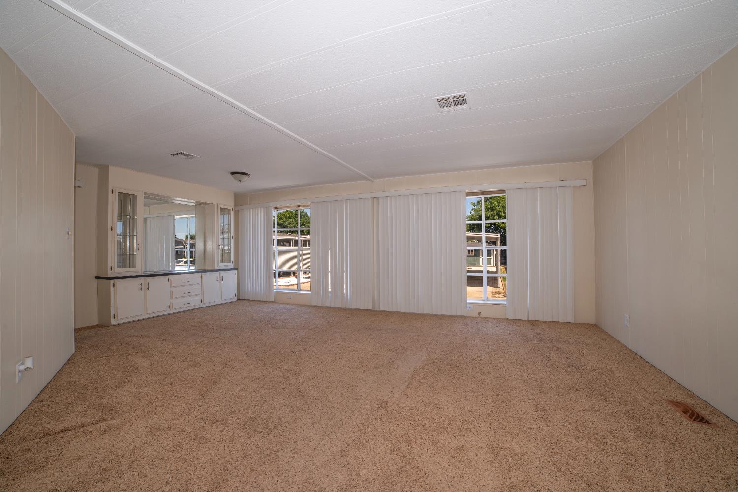 1200 South Carpenter Road, Unit 71 Modesto, CA 95351 - Photo 9 of 27 a view of an empty room with a window and wooden floor