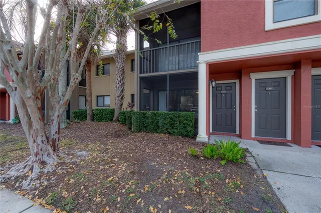 a view of a brick house with many windows next to a road