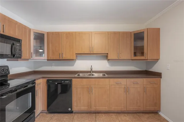 a kitchen with granite countertop a sink a stove and cabinets