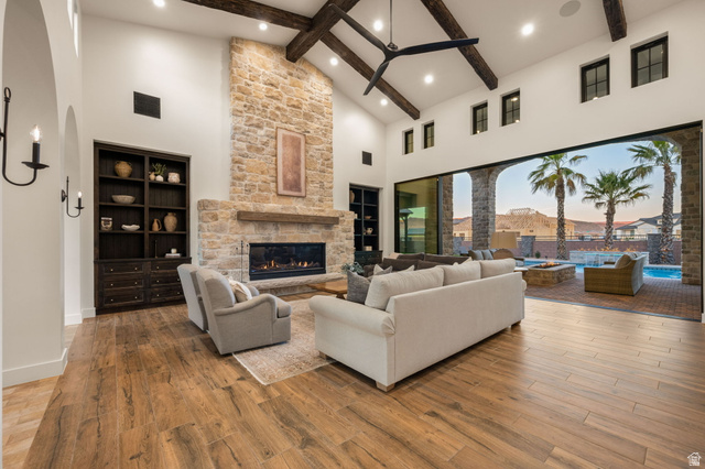 4871 South Homestead Way Washington, UT 84780 - Photo 11 of 151 Living room with a stone fireplace, hardwood / wood-style floors, built in features, vaulted ceiling, and arched walkways
