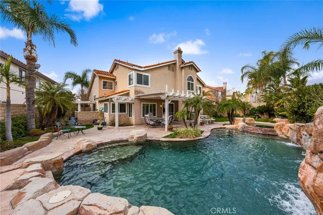 a front view of a house with swimming pool garden and patio