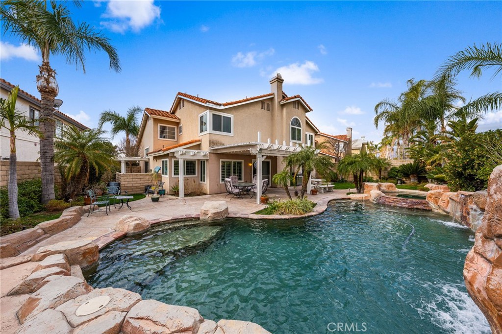 a front view of a house with swimming pool garden and patio