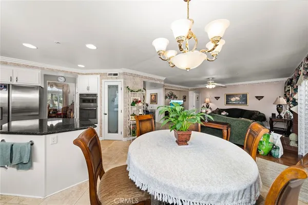 a view of a dining room with furniture a chandelier and wooden floor