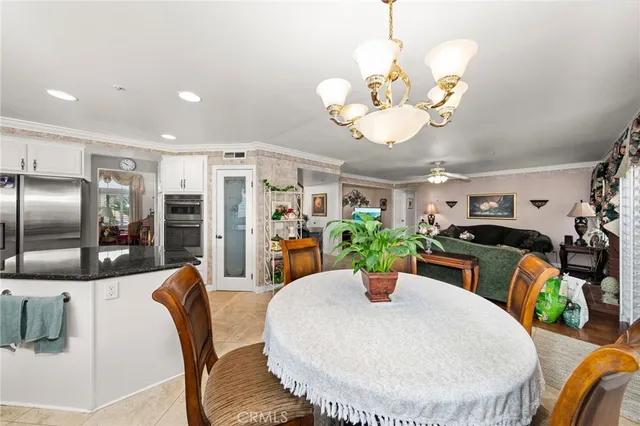 a view of a dining room with furniture a chandelier and wooden floor