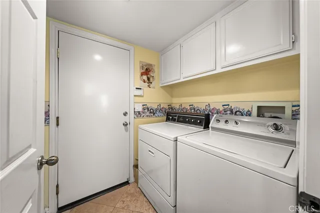a view of washer and dryer with kitchen in the background
