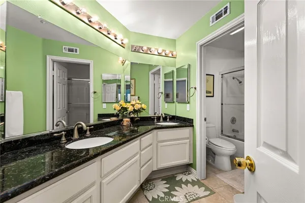 a spacious bathroom with a granite countertop sink and a mirror