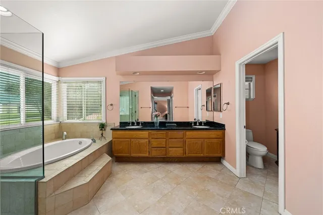 a bathroom with a granite countertop tub sitting next to a large window