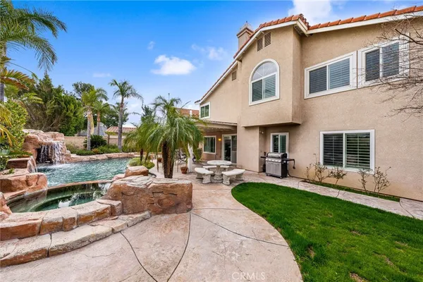 a view of a house with backyard sitting area and swimming pool