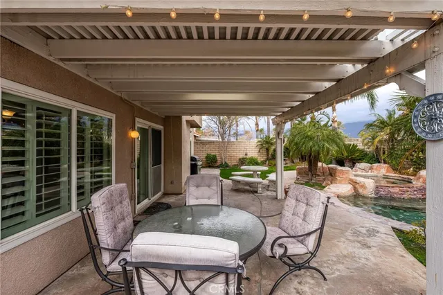 a view of a patio with table and chairs with wooden floor and fence