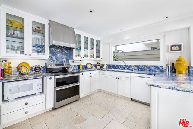 a kitchen with stainless steel appliances granite countertop a stove and cabinets