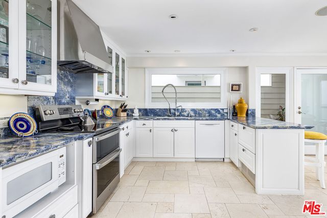 a kitchen with granite countertop white cabinets and white appliances