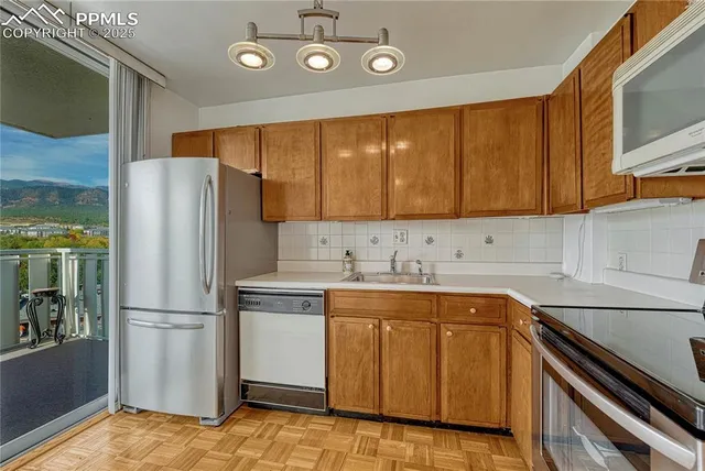 a kitchen with stainless steel appliances granite countertop a refrigerator a stove and a sink