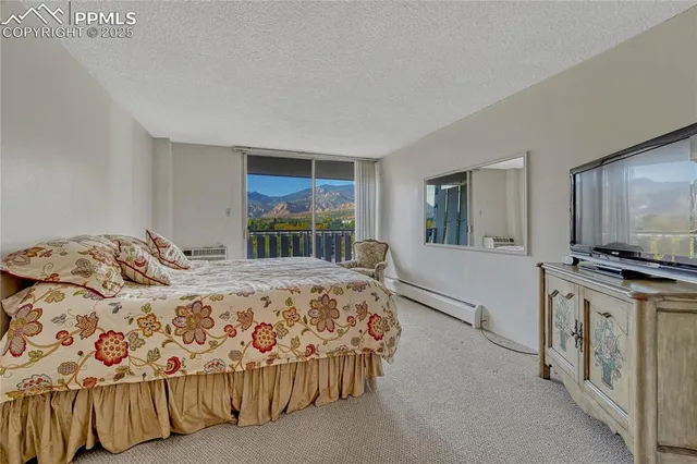 a bedroom with a large bed and a flat tv screen on dresser