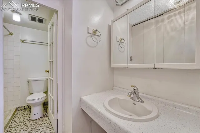 a bathroom with a sink a toilet and a mirror